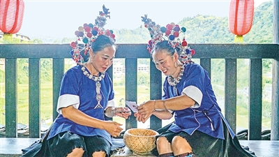     程陽(yáng)橋上，侗族婦女在展示制作侗族刺繡產(chǎn)品。繡品圖案精美、色彩艷麗，成為當(dāng)?shù)靥厣a(chǎn)業(yè)。
